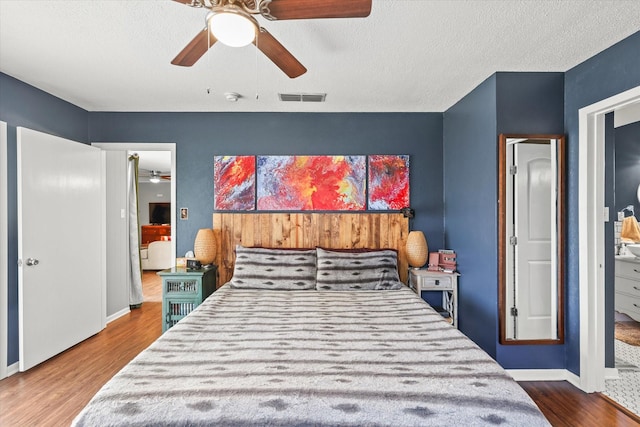 bedroom featuring ceiling fan, hardwood / wood-style floors, and a textured ceiling