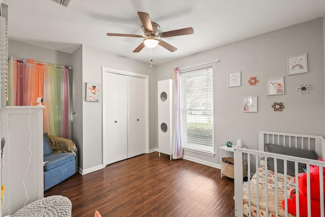 bedroom with dark wood-type flooring, ceiling fan, and a closet