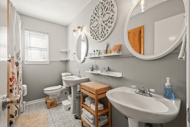 bathroom featuring double sink, tile patterned floors, and toilet