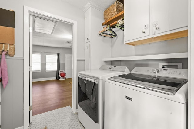 clothes washing area featuring cabinets and washing machine and clothes dryer