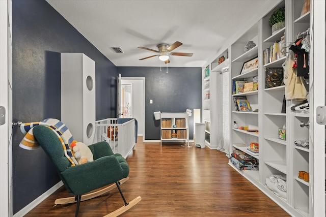 living area with ceiling fan and dark hardwood / wood-style flooring