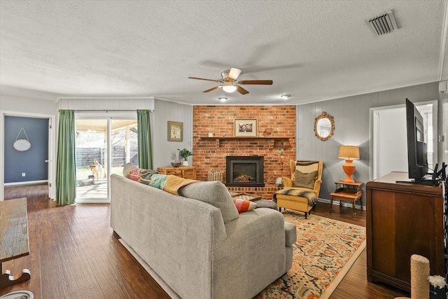 living room featuring a fireplace, dark hardwood / wood-style flooring, and a textured ceiling