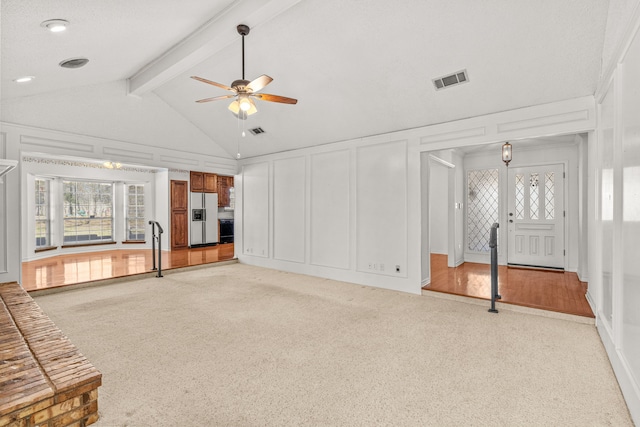 unfurnished living room with ceiling fan, high vaulted ceiling, and beam ceiling