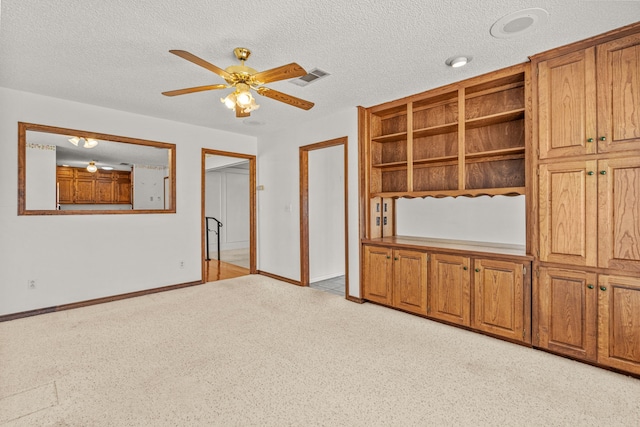 interior space with a textured ceiling and ceiling fan