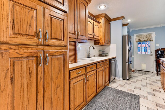 kitchen featuring ornamental molding, appliances with stainless steel finishes, sink, and decorative backsplash