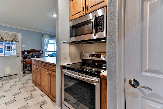 kitchen featuring tasteful backsplash, crown molding, and appliances with stainless steel finishes