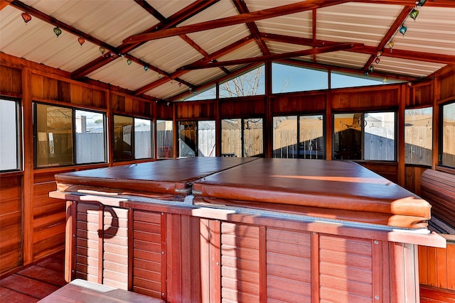 unfurnished sunroom featuring lofted ceiling and a jacuzzi