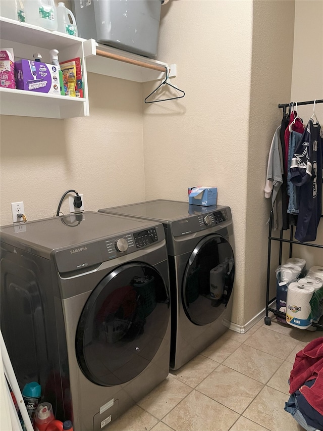 clothes washing area featuring washer and dryer and light tile patterned floors