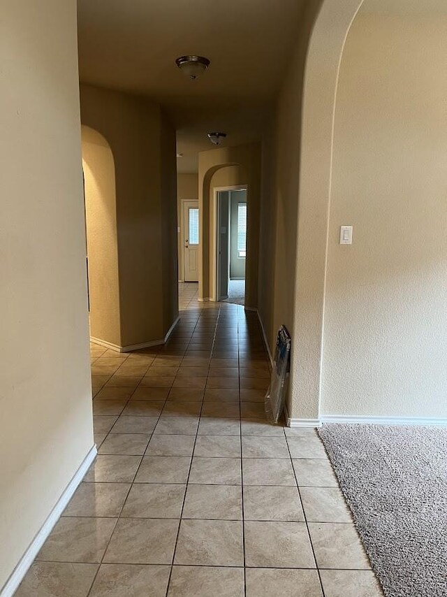 14125 Rabbit Brush Ln, Fort Worth, TX 76052 - hallway featuring arched walkways, light tile patterned flooring, and baseboards