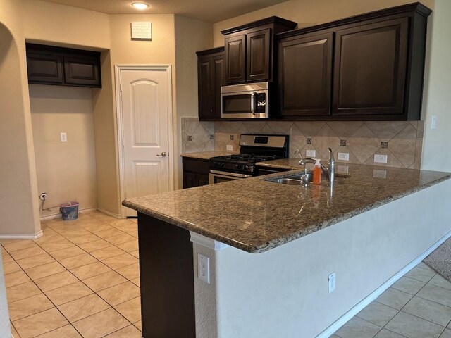 14125 Rabbit Brush Ln, Fort Worth, TX 76052 - kitchen featuring stainless steel appliances, a sink, a peninsula, and light tile patterned flooring