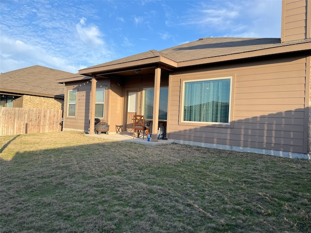 rear view of house with a lawn and a patio area