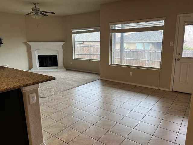 14125 Rabbit Brush Ln, Fort Worth, TX 76052 - unfurnished living room with healthy amount of natural light, a ceiling fan, a glass covered fireplace, and baseboards