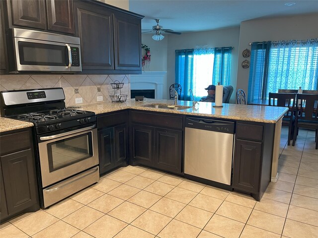 14125 Rabbit Brush Ln, Fort Worth, TX 76052 - kitchen featuring appliances with stainless steel finishes, a peninsula, a sink, a ceiling fan, and light tile patterned flooring