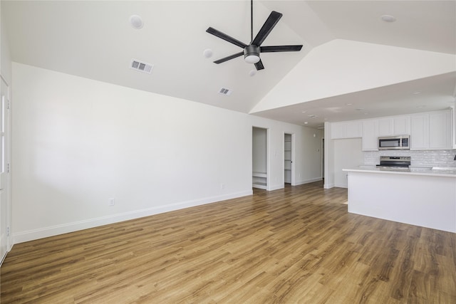 unfurnished living room featuring ceiling fan, high vaulted ceiling, and light wood-type flooring