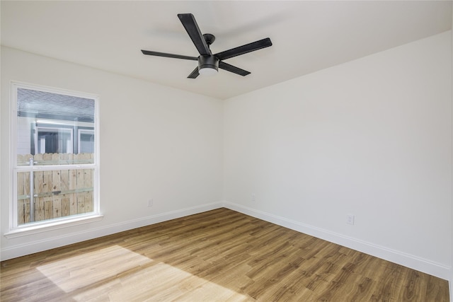 spare room featuring ceiling fan, plenty of natural light, and light wood-type flooring