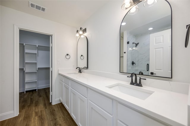 bathroom with wood-type flooring, an enclosed shower, and vanity