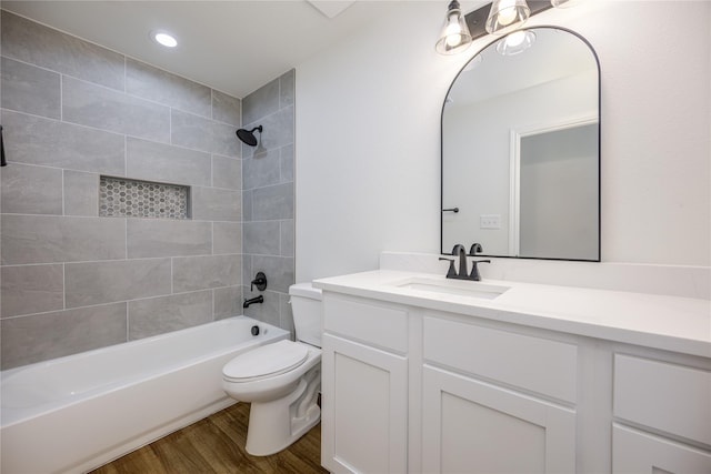 full bathroom featuring an inviting chandelier, tiled shower / bath combo, vanity, wood-type flooring, and toilet