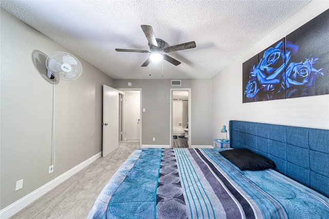 carpeted bedroom featuring ceiling fan, ensuite bath, and a textured ceiling