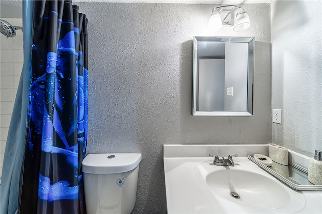 bathroom featuring a shower with curtain, sink, and toilet