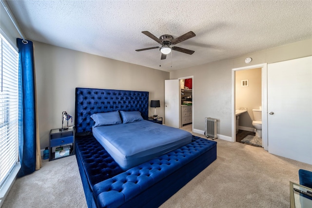 bedroom featuring ceiling fan, carpet, radiator heating unit, and a textured ceiling