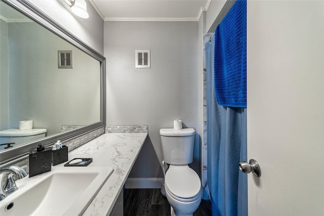 bathroom featuring crown molding, hardwood / wood-style floors, vanity, toilet, and walk in shower