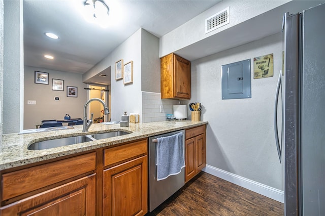 kitchen with sink, dark hardwood / wood-style flooring, electric panel, light stone counters, and stainless steel appliances