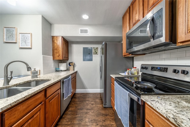 kitchen with sink, dark wood-type flooring, appliances with stainless steel finishes, electric panel, and light stone countertops