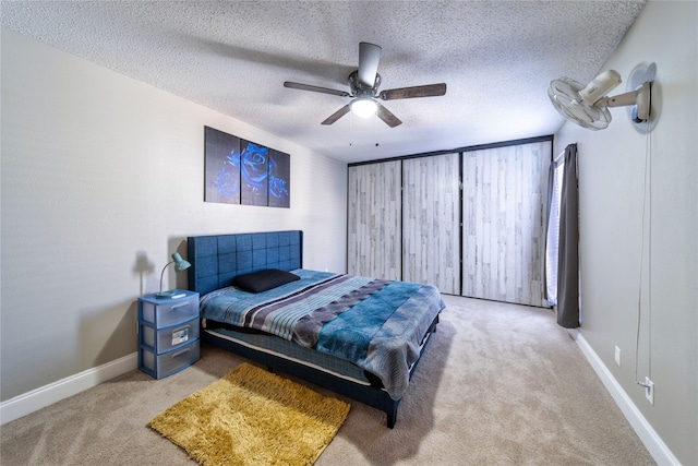 bedroom featuring light carpet, ceiling fan, and a textured ceiling