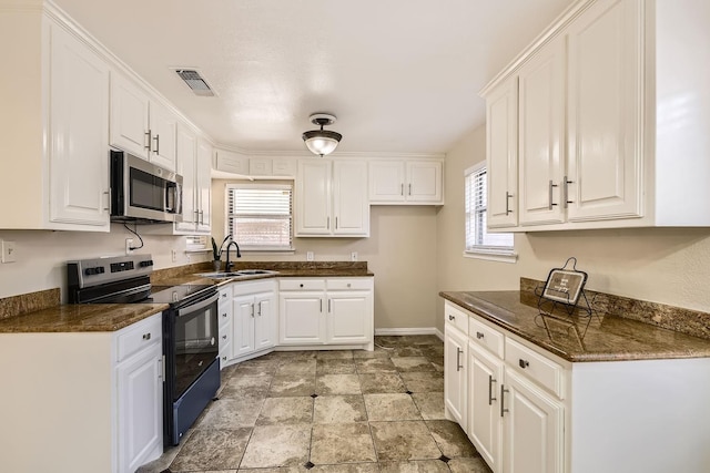 kitchen featuring white cabinetry, appliances with stainless steel finishes, sink, and a healthy amount of sunlight