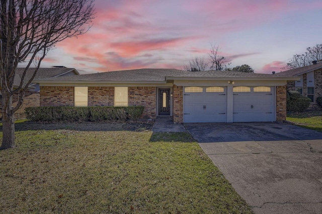 single story home with a garage and a lawn