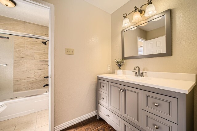 bathroom with tiled shower / bath combo and vanity