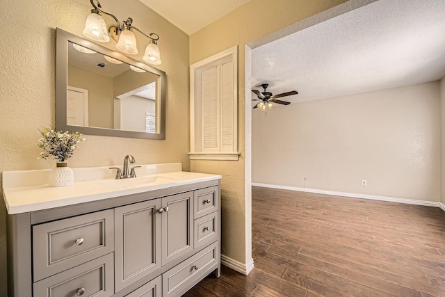 bathroom with vanity, a textured ceiling, wood-type flooring, and ceiling fan