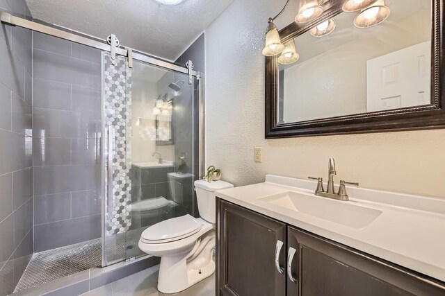 bathroom featuring walk in shower, vanity, toilet, and a textured ceiling