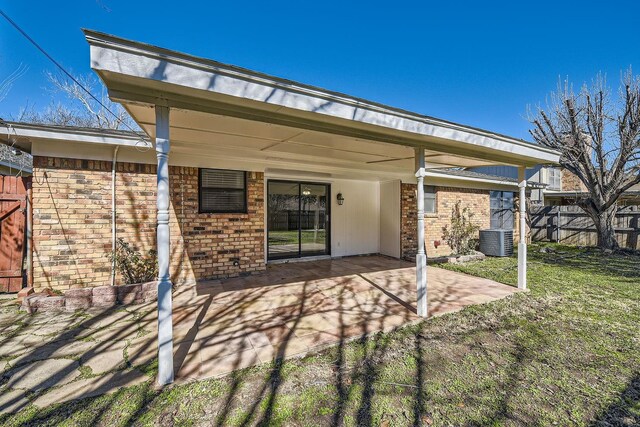 rear view of house with a patio, central AC unit, and a lawn