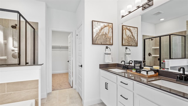 bathroom with vanity, a shower with shower door, and tile patterned floors