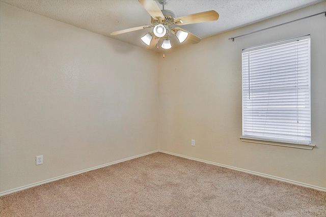 spare room with a wealth of natural light, light carpet, ceiling fan, and a textured ceiling