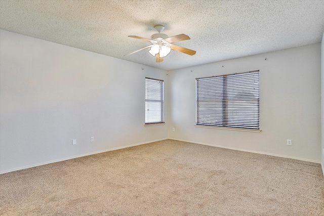 carpeted empty room featuring a textured ceiling and ceiling fan