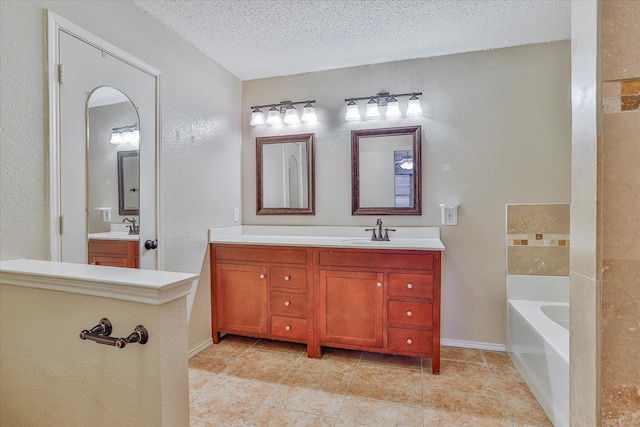 bathroom with vanity, a bathtub, and a textured ceiling