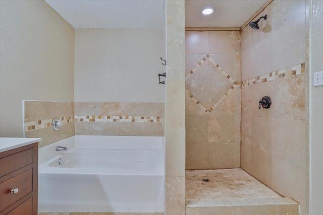 bathroom with vanity, a textured ceiling, and plus walk in shower