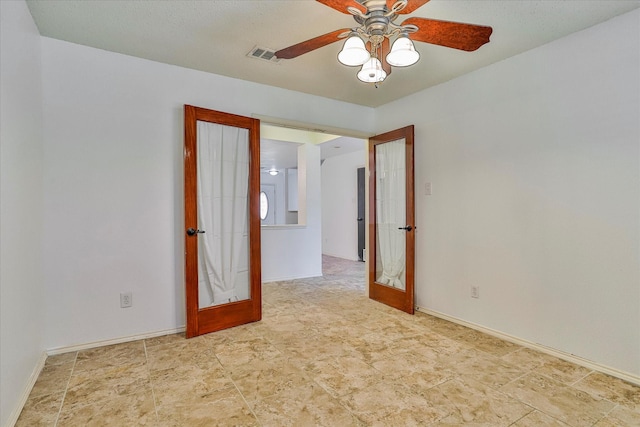 empty room featuring french doors and ceiling fan