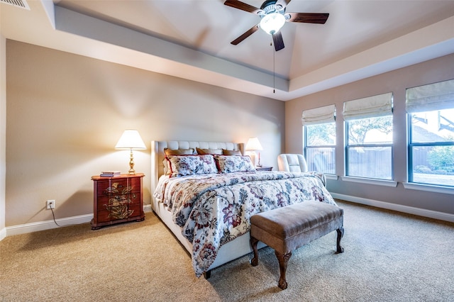 carpeted bedroom featuring a raised ceiling and ceiling fan