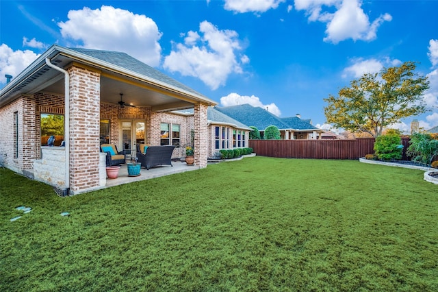 view of yard featuring an outdoor living space, ceiling fan, and a patio area