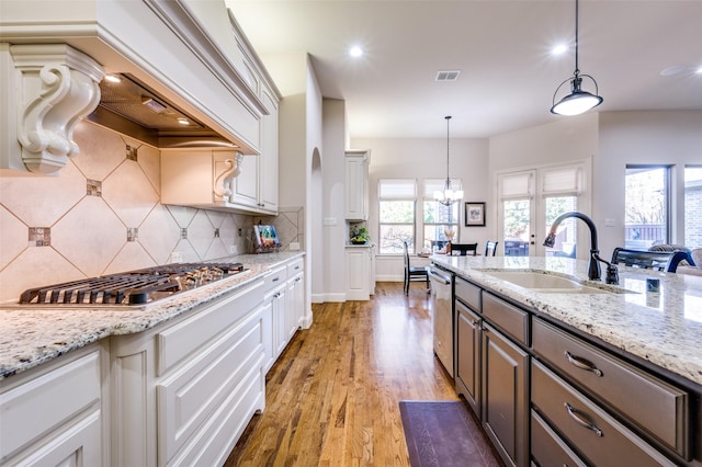 kitchen featuring sink, decorative light fixtures, stainless steel appliances, and white cabinets