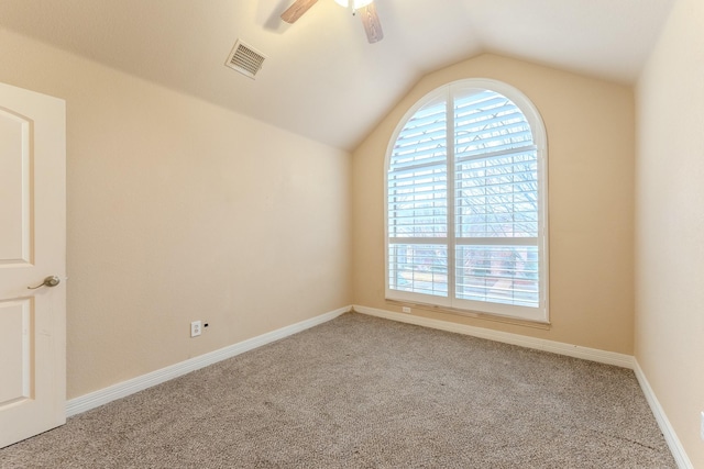 empty room featuring lofted ceiling, light colored carpet, and ceiling fan