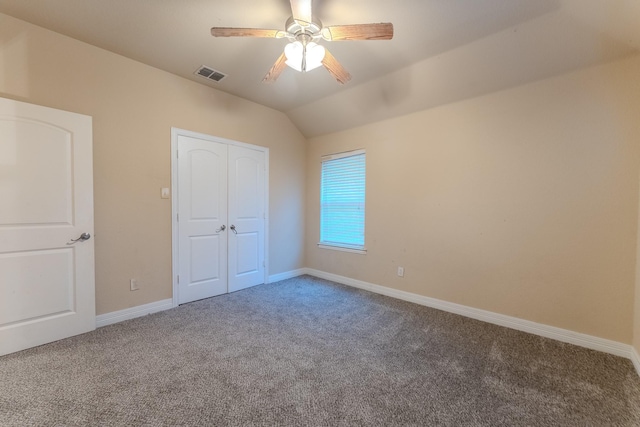 unfurnished bedroom featuring ceiling fan, a closet, vaulted ceiling, and carpet