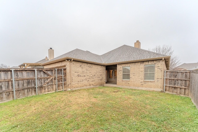 rear view of house featuring a yard