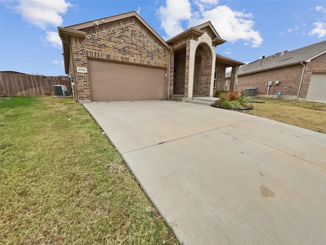 view of front of home with cooling unit, a garage, and a front lawn