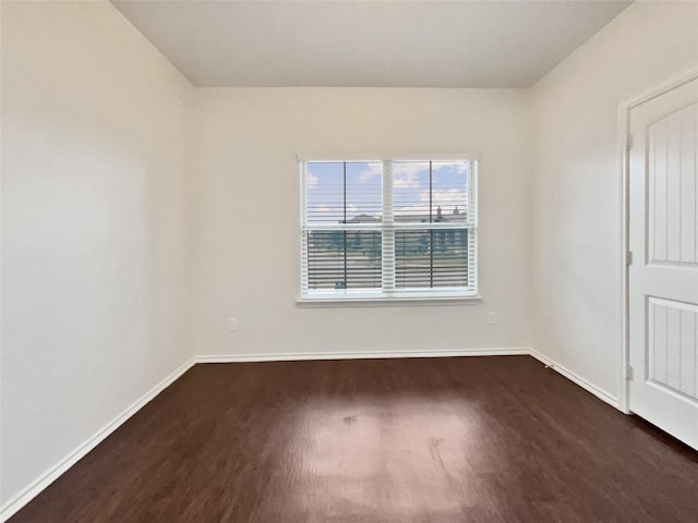 empty room with dark hardwood / wood-style flooring