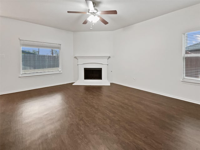 unfurnished living room with ceiling fan and dark hardwood / wood-style floors