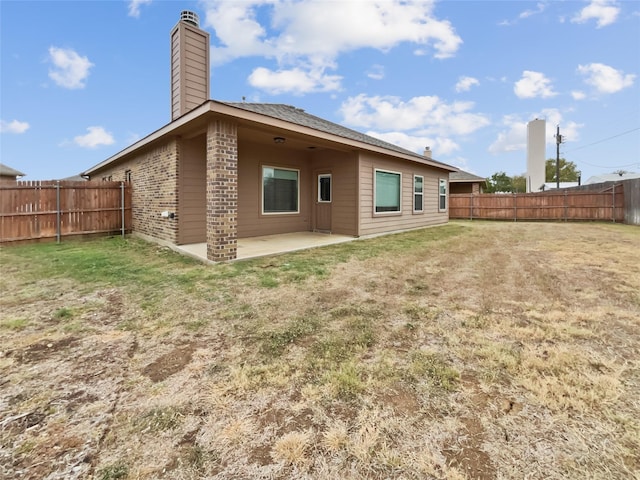 back of property with a yard and a patio area